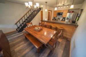 a kitchen and dining room with a wooden table and chairs at Ski Run 303 by SummitCove Lodging in Keystone