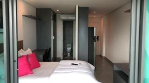 Un dormitorio con una cama blanca con almohadas rosas. en Frente Mar Salvador Bahia, en Salvador