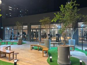 Un edificio con bancos y árboles delante. en Frente Mar Salvador Bahia, en Salvador