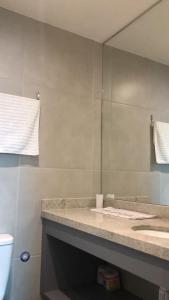 y baño con espejo, lavabo y aseo. en Frente Mar Salvador Bahia, en Salvador