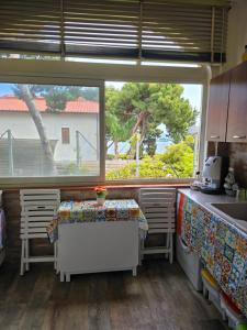 a kitchen with a table and two chairs and a window at Chris House Mondello in Palermo