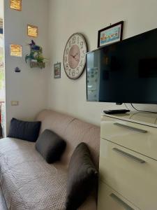 a living room with a couch and a clock on the wall at Chris House Mondello in Palermo