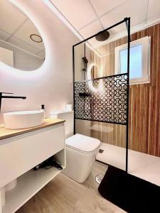 a bathroom with a toilet and a sink and a mirror at La Perla del Pinatar in San Pedro del Pinatar