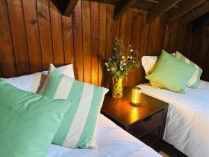 ein Schlafzimmer mit zwei Betten und einer Blumenvase auf einem Tisch in der Unterkunft Casa da Vela by Férias em Figueira in Buarcos e São Julião