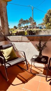 einen Stuhl und einen Tisch auf einer Terrasse in der Unterkunft Casa da Vela by Férias em Figueira in Buarcos e São Julião