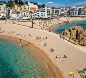 a group of people on a beach in the water at Habitació amb encant a Blanes in Blanes