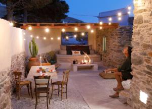 a man sitting on a patio at night with lights at Onos Eco Living in Mési