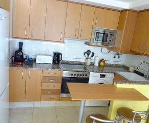 a kitchen with wooden cabinets and a stove top oven at Casa el Alfar mudéjar in Teruel +22 photos