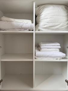 a white closet with white towels and a pillow at Small but with character in Kaunas