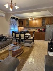 a living room and kitchen with a table and chairs at ARZO Apartments in Berat