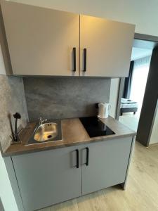 a kitchen with white cabinets and a sink at Pension Meeresluft in Rostock
