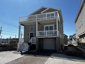 a large house with a balcony and a garage at Roof-Top Deck With Ocean & Bay Views Single Family Beach Badges Private Yard Ping Pong And Pool Table Wifi 1 Block From Ocean 15 Blocks To Bay in Ship Bottom