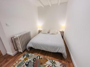 a small bedroom with a bed and a radiator at Calme et Confort sur les Hauteurs de Montauban in Montauban +13 photos