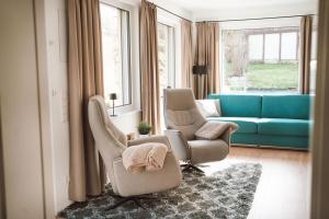 齐根吕克Gemütliches Ferienhaus "Glück" mit Gartensauna - Ideal für Familien & Paare的有两把椅子和一张沙发的客厅