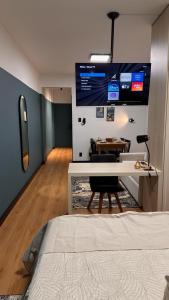 a room with a bed and a table and a tv at Seu Refúgio Apartamento moderno e aconchegante no Centro de Juiz de Fora in Juiz de Fora