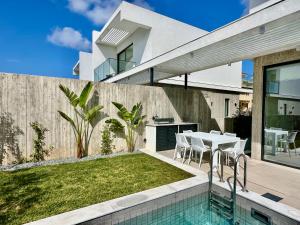 a house with a swimming pool and a table and chairs at Elysian Blue villa 2 in Paphos City
