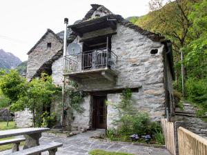 an old stone house with a balcony and a porch at Verzasca Lodge Cassiopea in Frasco