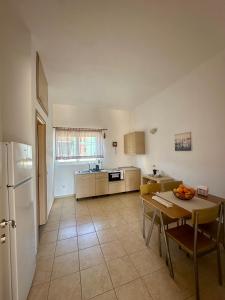 a kitchen with a table and a refrigerator at Garden View Appartment (Thanasis) in Kalavárda