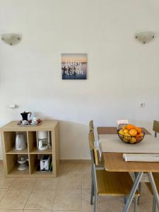 a dining room with a table with a bowl of oranges at Garden View Appartment (Thanasis) in Kalavárda