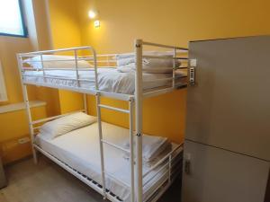 two bunk beds in a room with a refrigerator at Cinhouse in Milan