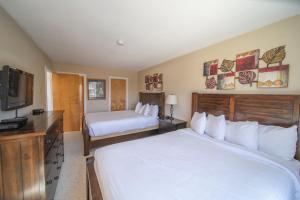 a hotel room with two beds and a flat screen tv at Edgewater 1451 by SummitCove Lodging in Keystone +68 photos