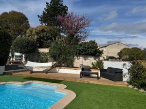 un cortile con amaca e piscina di Maison 3 chambres, piscine privée terrain de pétanque a Carcassonne