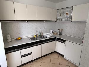 a kitchen with white cabinets and a sink at Apartma Pri noni Silvi in Tolmin