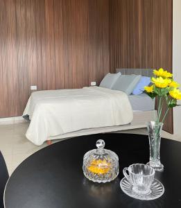 阿拉皮拉卡Estúdio aconchego do agreste的一间卧室配有一张床和一张鲜花桌