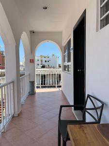 a room with a balcony with a table and a chair at Hotel Marcianito in Isla Mujeres