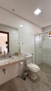 a bathroom with a toilet and a sink and a shower at Estância Pontello - próximo ao aeroporto de Confins in Confins