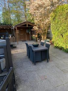 a wooden table and chairs with a bowl on it at 6-persoonschalet op 5-sterrenvakantiepark in Suameer