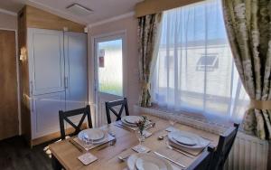 a dining room table with chairs and plates and a window at Belinda, Church Farm, Pagham in Pagham +16 photos
