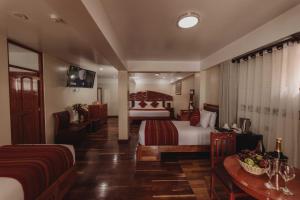 库斯科Quechua Hotel Cusco的酒店客房配有一张床和一张桌子,桌子上装有四面 ⁇ 