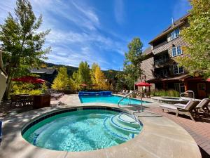einen Pool in einem Garten mit Stühlen und einem Gebäude in der Unterkunft Silver Mill 8302 by SummitCove Lodging in Keystone