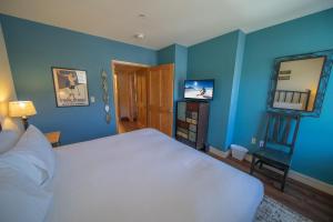 Schlafzimmer mit blauen Wänden, einem Bett und einem Spiegel in der Unterkunft Silver Mill 8302 by SummitCove Lodging in Keystone + 41 Fotos