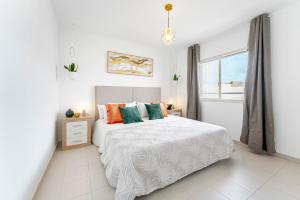 a white bedroom with a bed and a window at Lolas in Puerto del Carmen