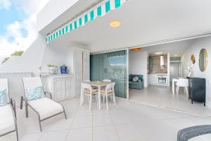 a balcony with a table and chairs and a kitchen at Lolas in Puerto del Carmen