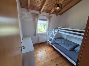 a bedroom with a bunk bed and a window at Rotes Ferienhaus im charmanten Schwedenhausviertel in Haselünne