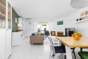 a kitchen and living room with a table and chairs at Apartment Estrelícia Direct beach access in Porches