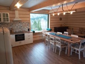 a kitchen and dining room with a table and chairs at Chata pod Jelenim Skokiem in Cisna