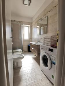 a bathroom with a washing machine and a sink at Villa Denise in Pulsano