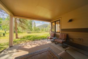 una veranda schermata con 2 sedie e un tavolo di Quicksilver 1617 by SummitCove Lodging a Keystone