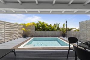 una piscina in un cortile con recinzione in legno di Bungalow Club Océar Love a Le Gosier