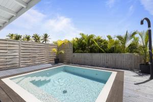 una piscina in un cortile con recinzione in legno di Bungalow Club Océar Love a Le Gosier