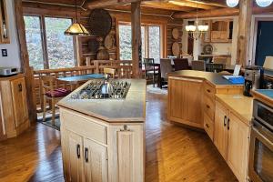 a large kitchen with wooden cabinets and a dining room at Viewtopia in Suttons Bay