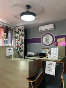 a waiting area of a salon with a counter and chairs at Hotel Marcianito in Isla Mujeres