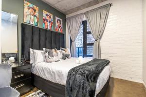 a bedroom with a large bed and a window at Cosy 103 City Building apartment in Maboneng, with free wifi in Johannesburg