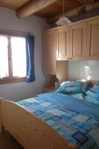 a bedroom with a bed with a blue comforter at Agritur Maso Gosserhof in Frassilongo +29 photos