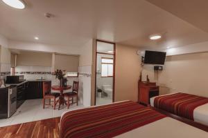 a hotel room with two beds and a kitchen at Quechua Hotel Cusco in Cusco