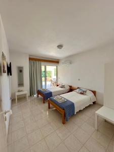 a bedroom with two beds and a balcony at Green View Appartment (Thanasis 2) in Kalavárda +9 photos
